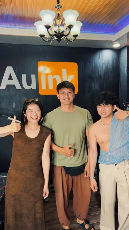 Clients and artist inside the AU Ink tattoo studio