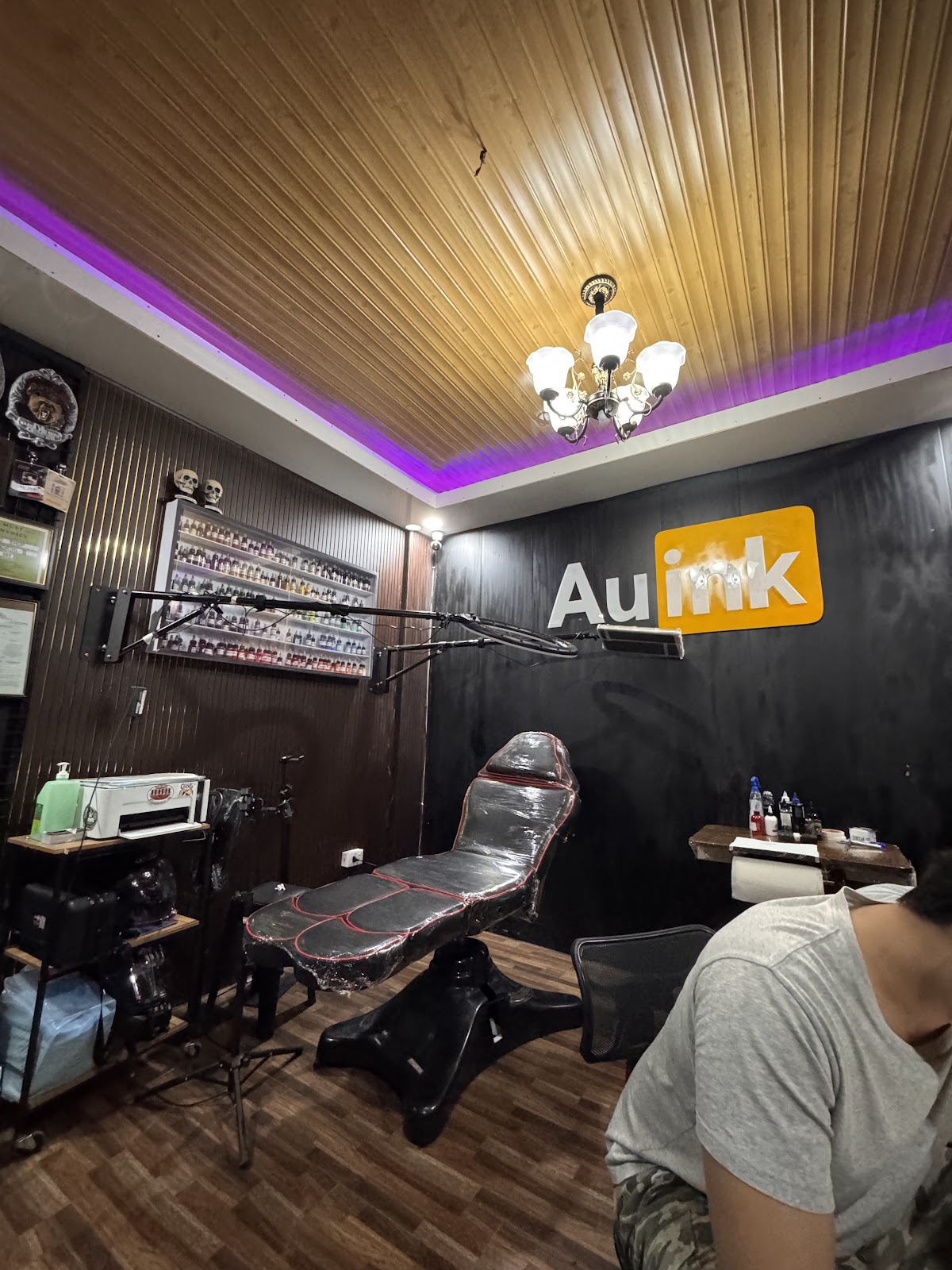 Clean black-and-mango AU Ink tattoo studio interior